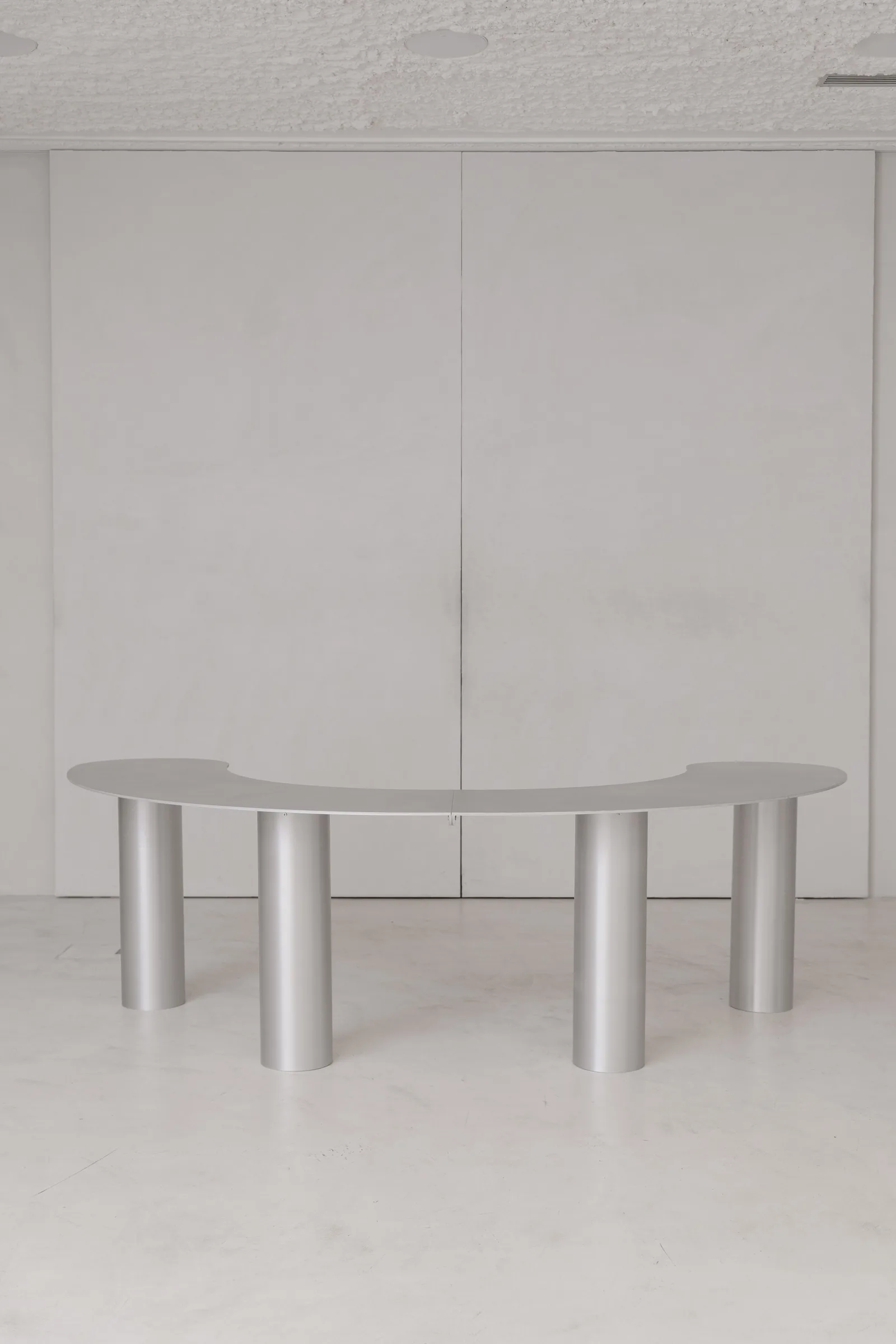 Bottone aluminium table seen from the front at Holographik Space, Zagreb