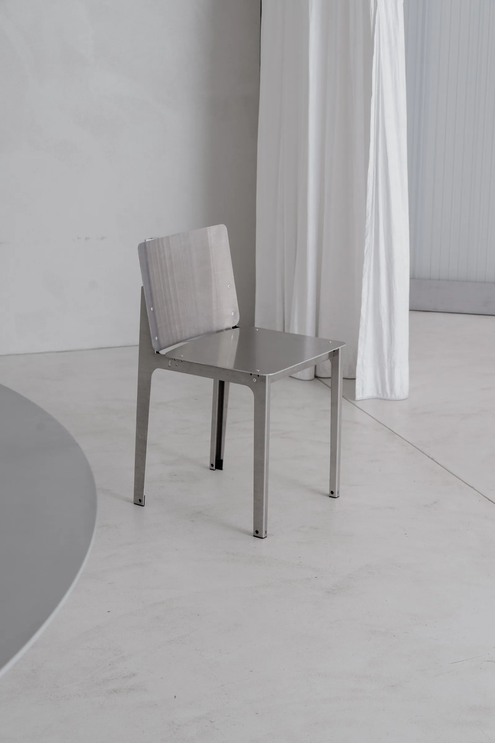 Bottone aluminium chair beside the curtain at Holographik Space, Zagreb