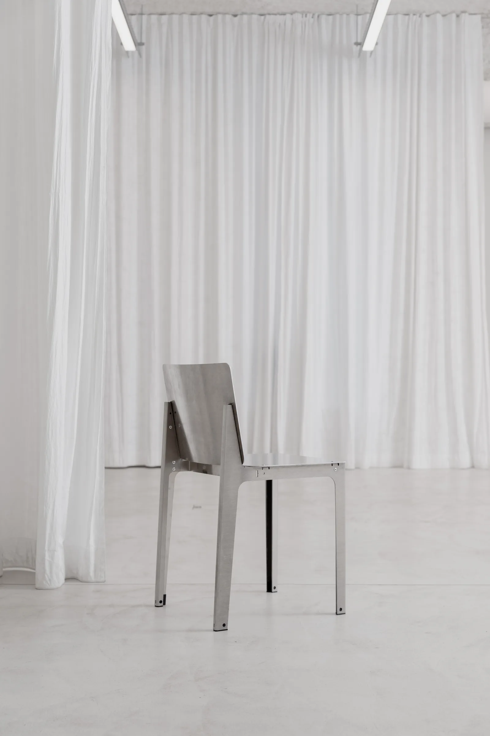 Bottone aluminium chair seen from behind at Holographik Space, Zagreb