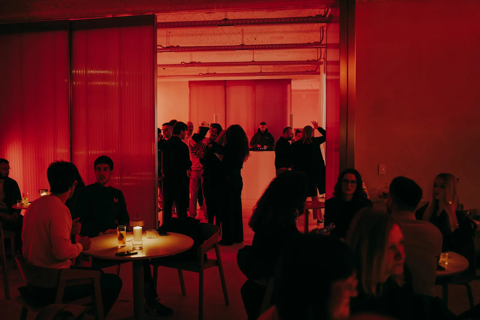 Guests around the tables and along the wall during an evening at Holographik Space