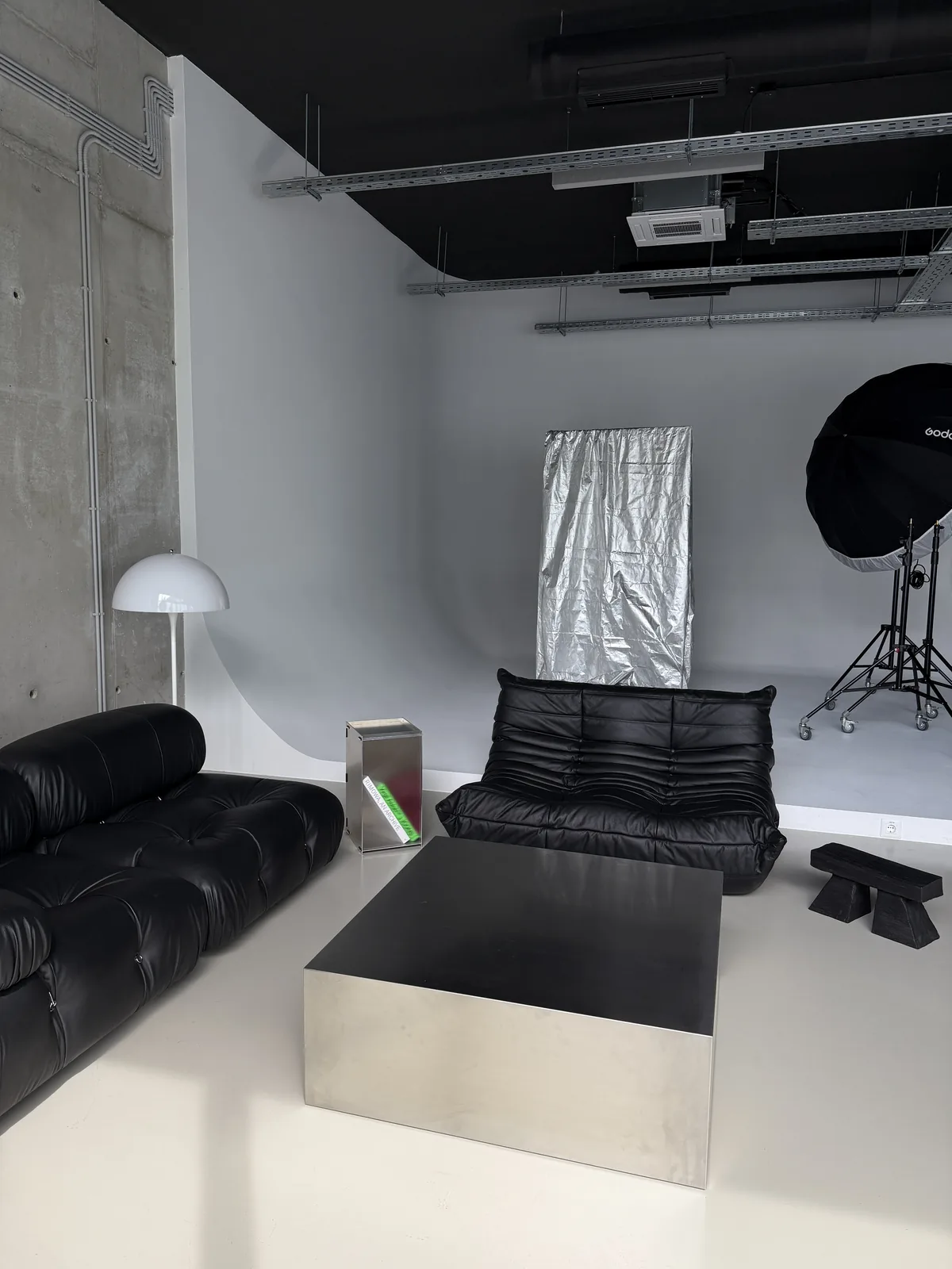 Camaleonda sofa, a stainless steel table and a charred wood stool