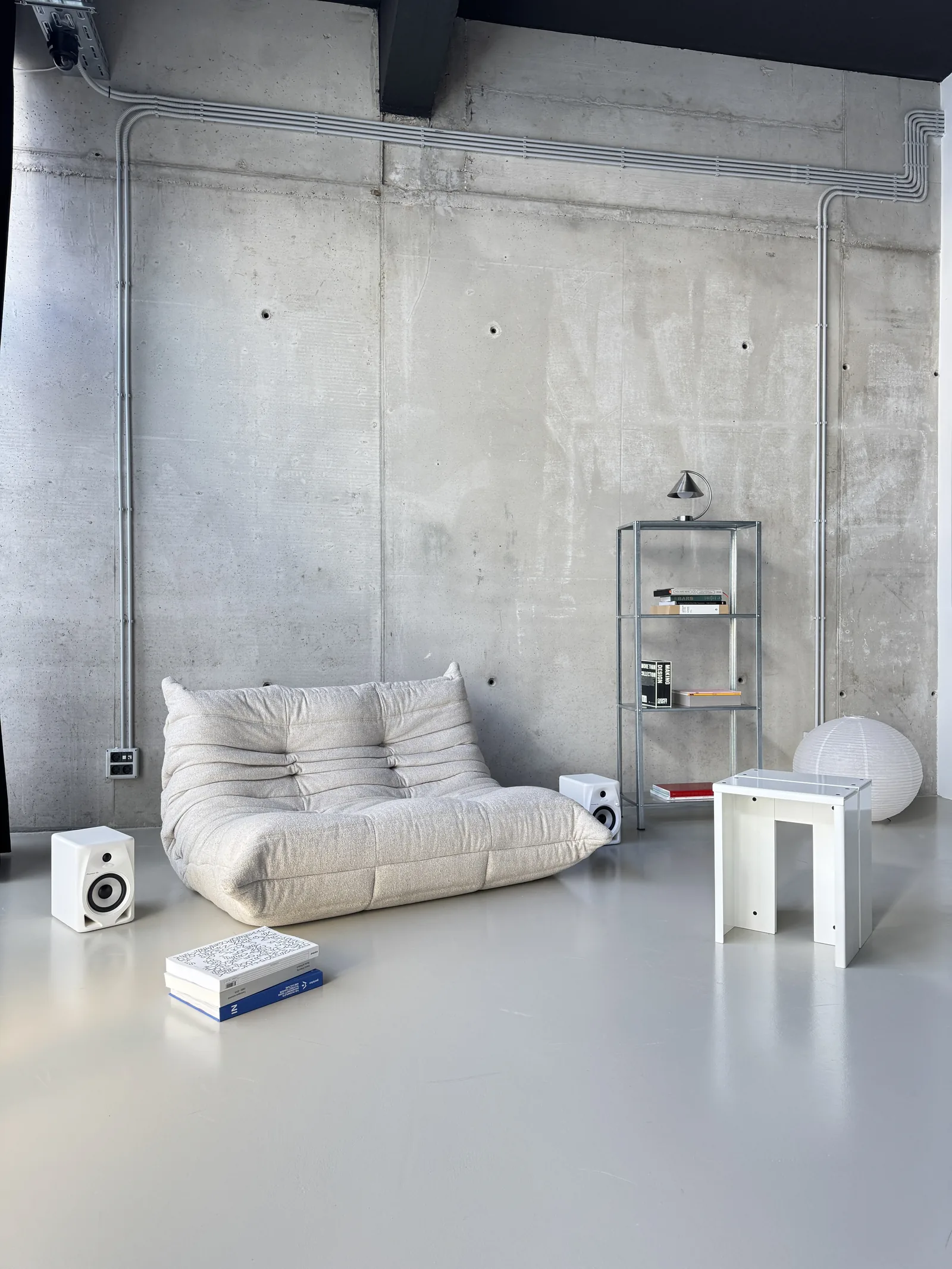 White Togo sofa with a steel shelving unit and a plinth