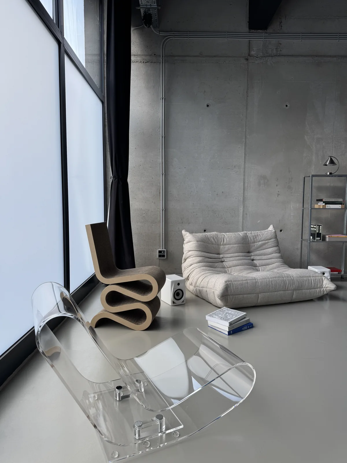 Wiggle Side Chair, an acrylic chair and a white Togo by the window