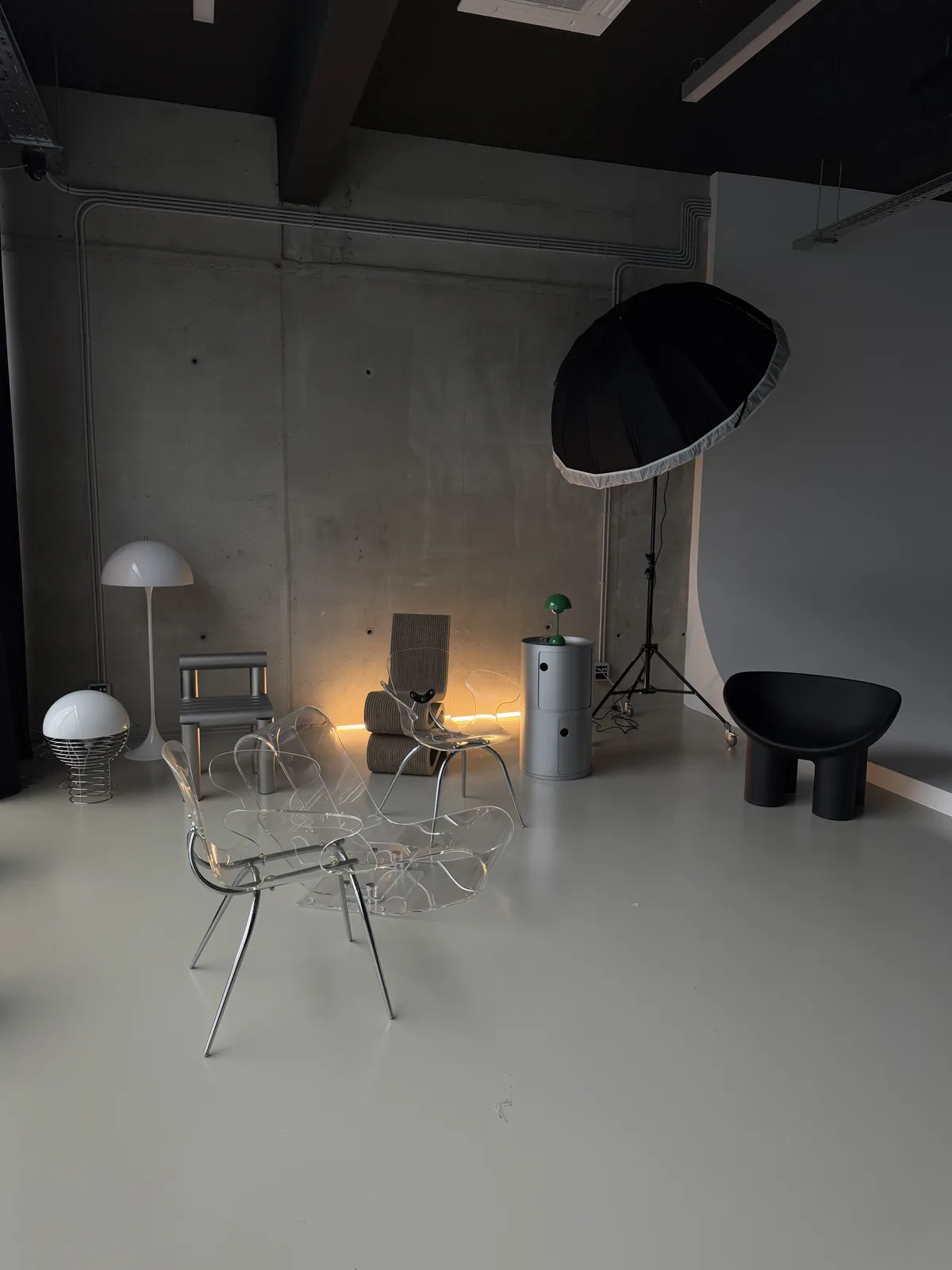 Wire and acrylic chairs with a Panthella lamp under studio light