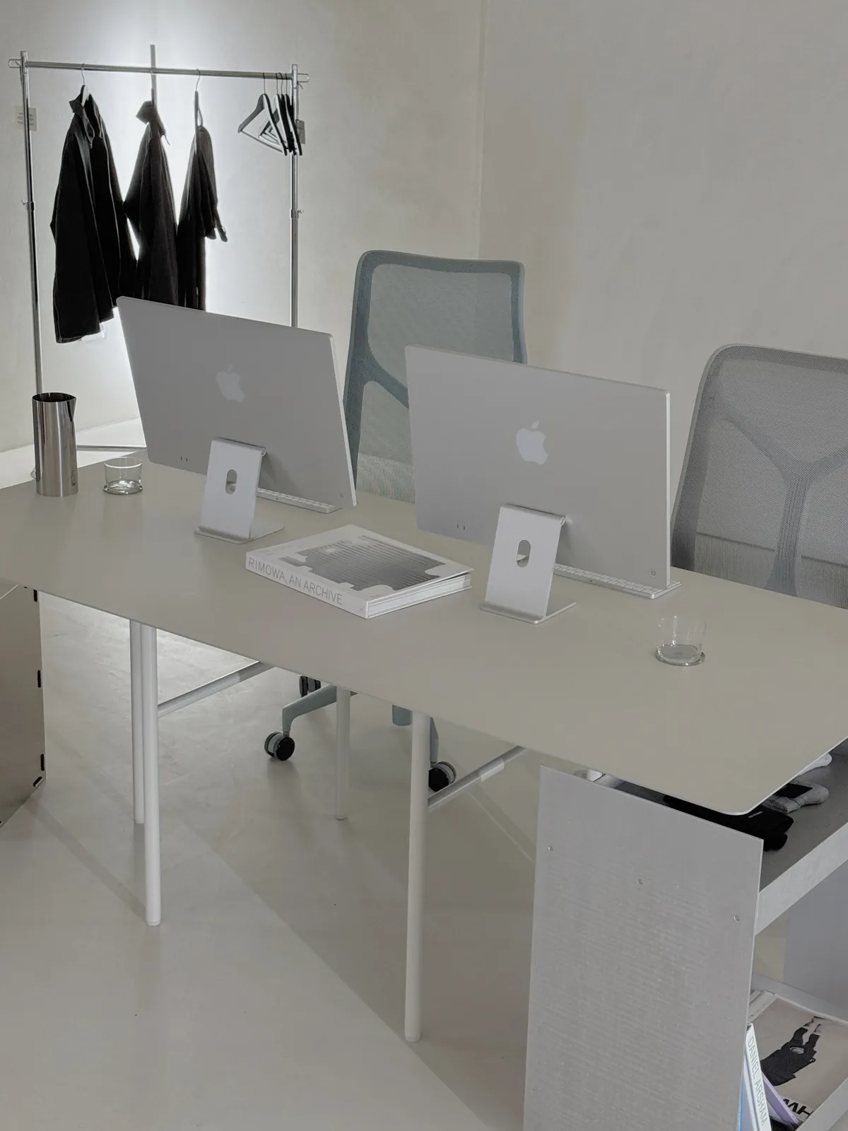 Office setup: a long desk with two iMacs and mesh chairs
