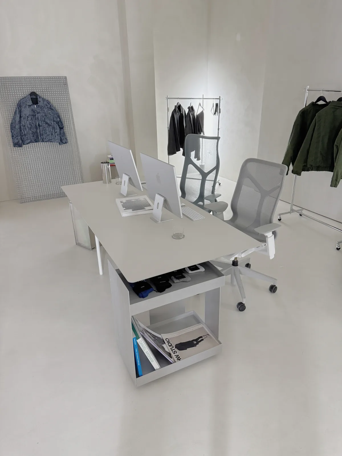 Office setup with a clothing rack and a stainless steel desk