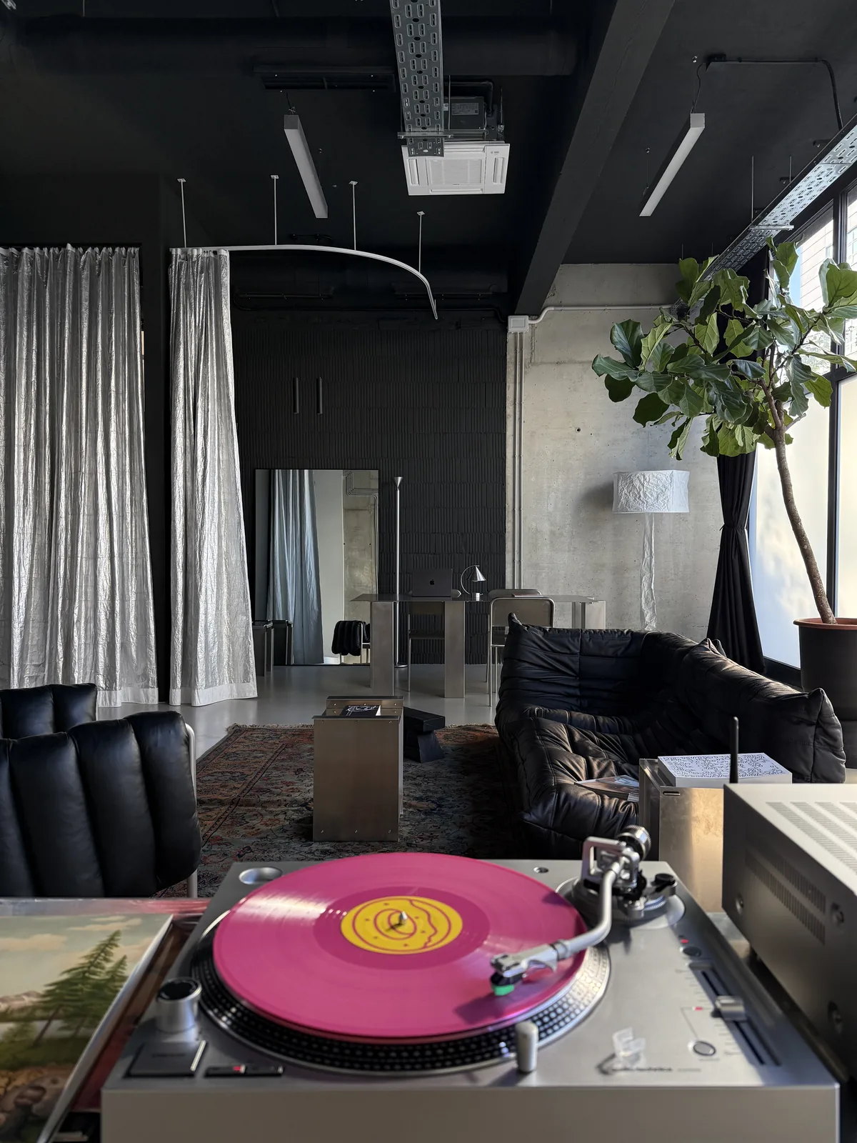 Turntable with a pink record on a lounge table