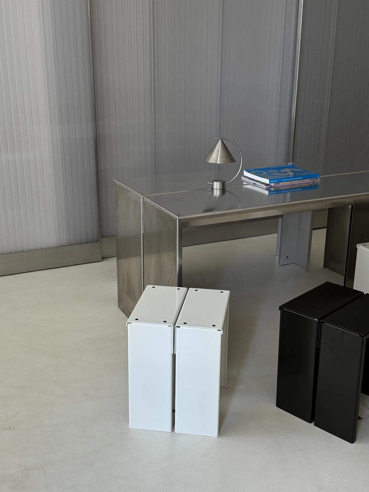 Steel desk with black and white stools by the window