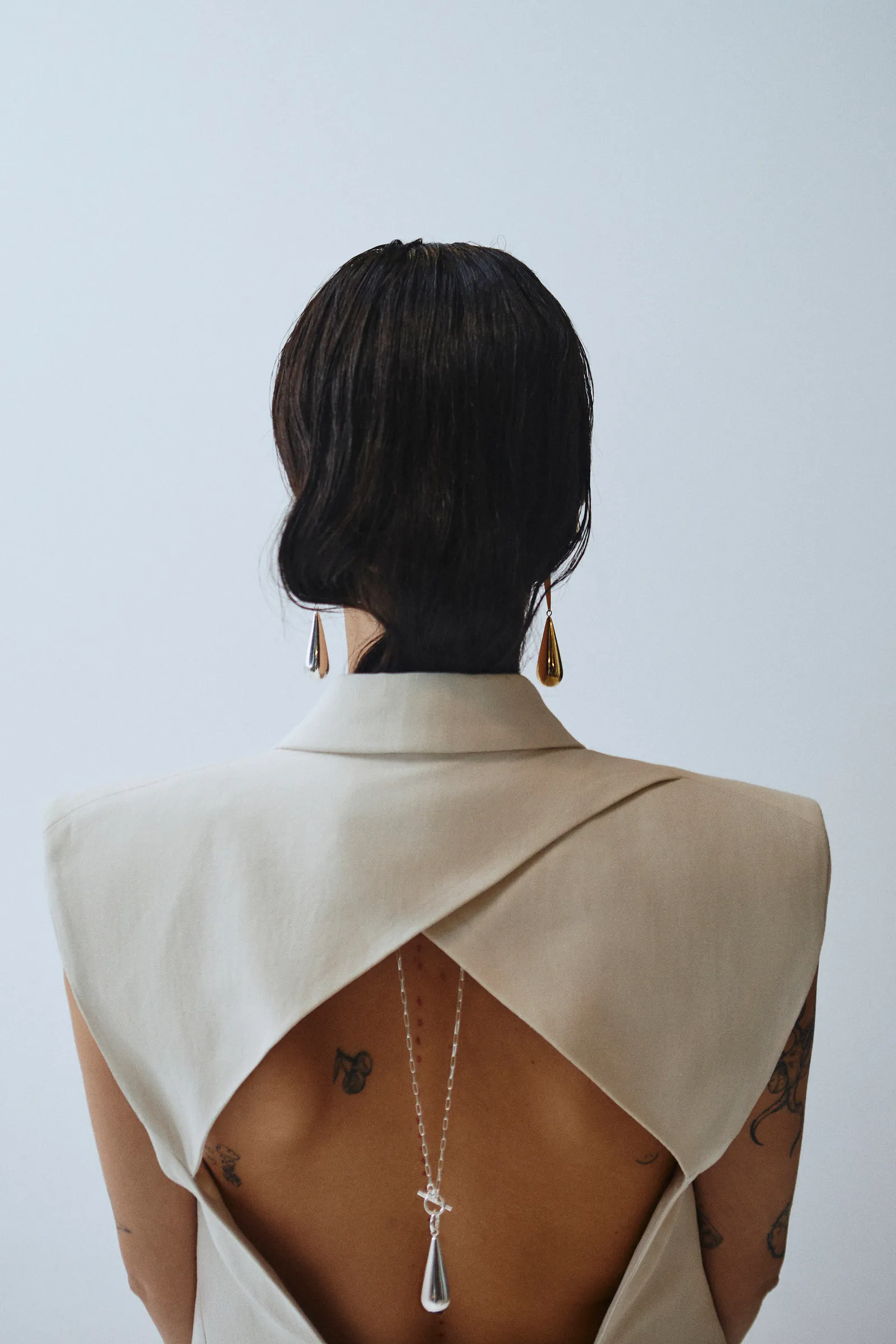 Jewellery shot, back to the camera on a pale wall